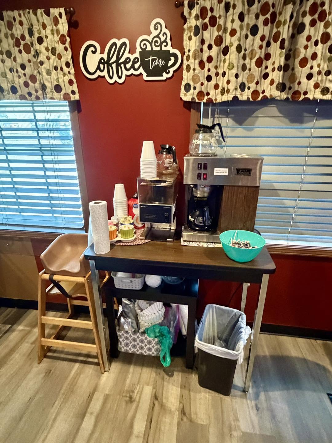 Self-serve coffee station with coffee makers and cups at Angelo's Express